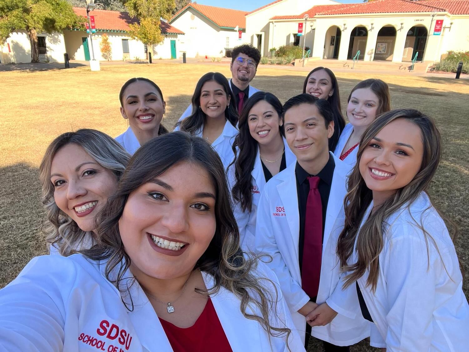 The inaugural cohort of SDSU's Calexico campus nursing program celebrates after their white coat ceremony to kick off clinical training.
