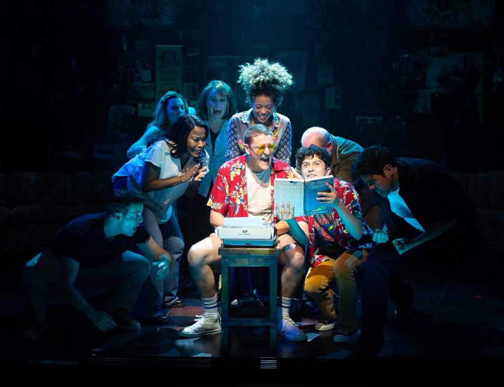 Hunter S. Thompson Musical cast huddled around a copy of The Great Gatsby