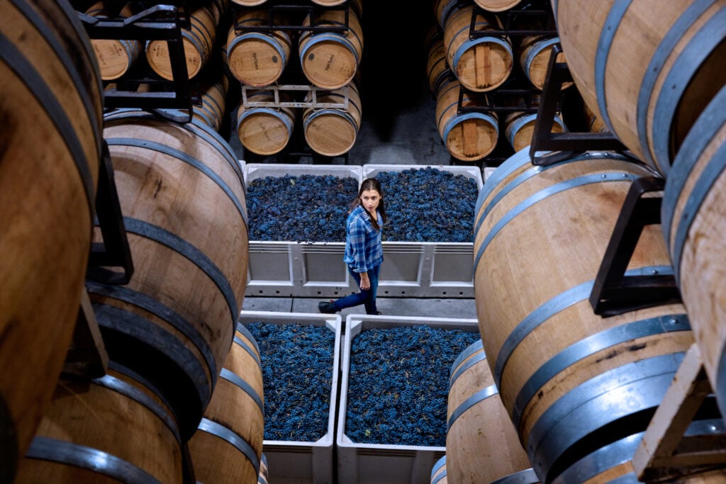 Temecula winemaker Olivia Bue of Robert Renzoni Vineyards strolls between barrels of aging wine