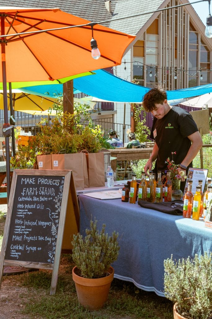 Immigrant at MAKE Projects managing a farm stand and locally made products