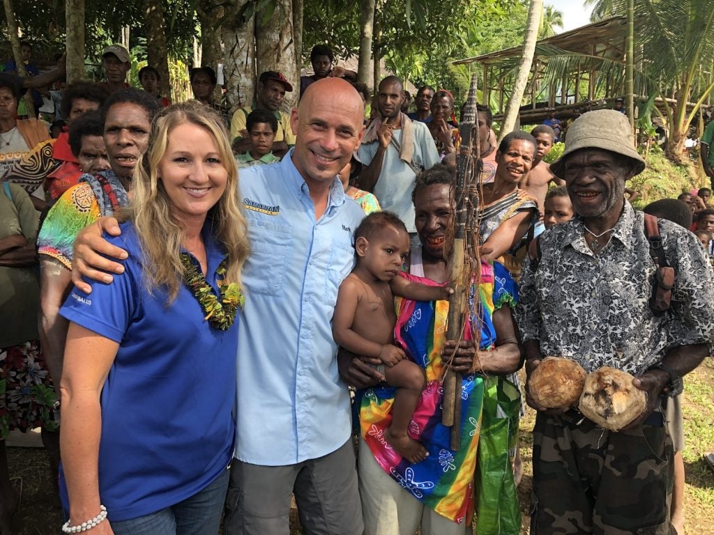 Founder and CEO of Samaritan Aviation Mark Palm and his wife hugging villagers of Papa New Guinea