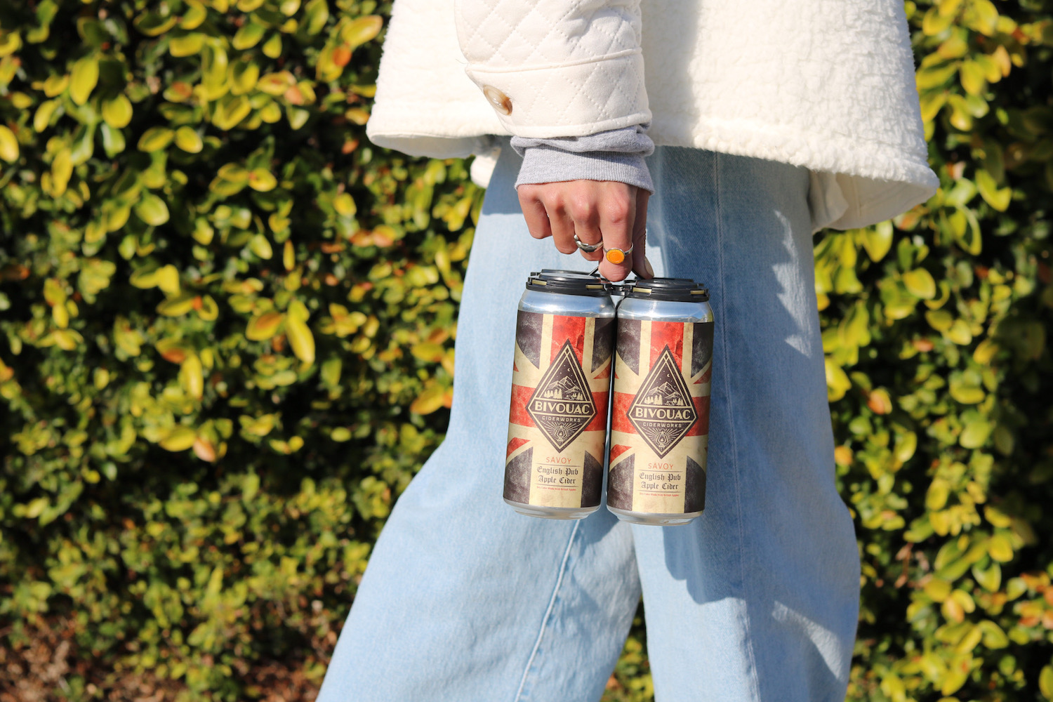 Woman walking with a 4-pack of Bivouac Ciderworks cider