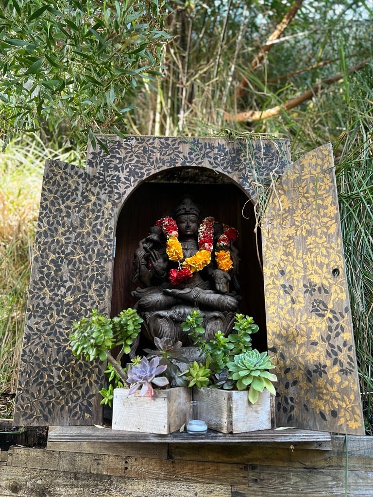 A buddhist statue at the inn garden surrounded by succulents