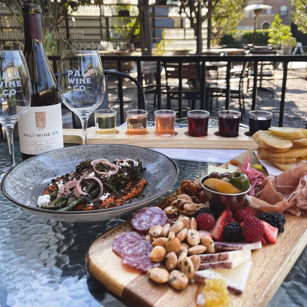 A table at Pali Wine Co. featuring a charcuterie board and a wine flight