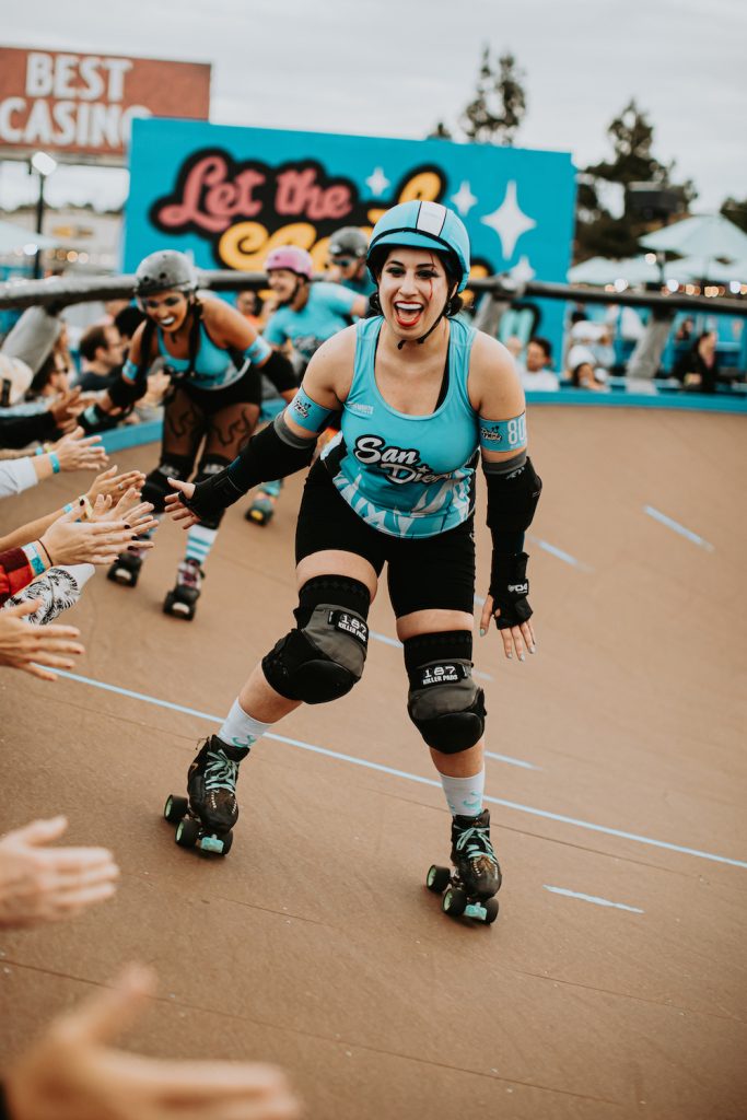 San Diego Wildfires players high fives fans of the roller derby bout 