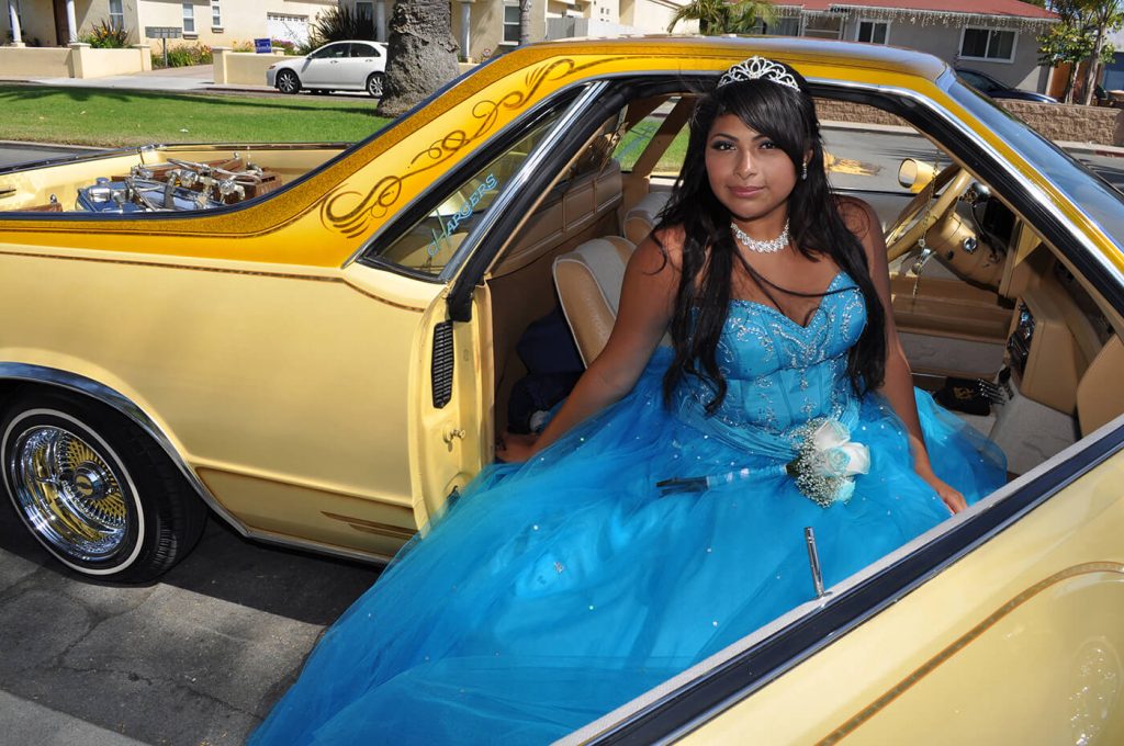 From Angélica Escoto art project, They don't dance alone, a young girl in a blue quinceanera dress getting out of a yellow car