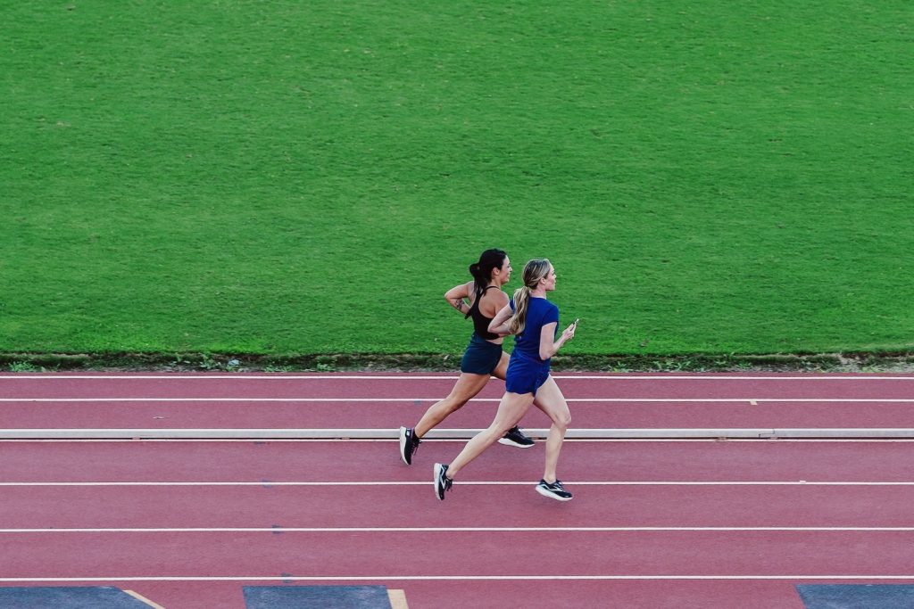 SDM Digital Managing Editor Nicolle Monico running side-by-side on a track with US gold medalist Chari Hawkins