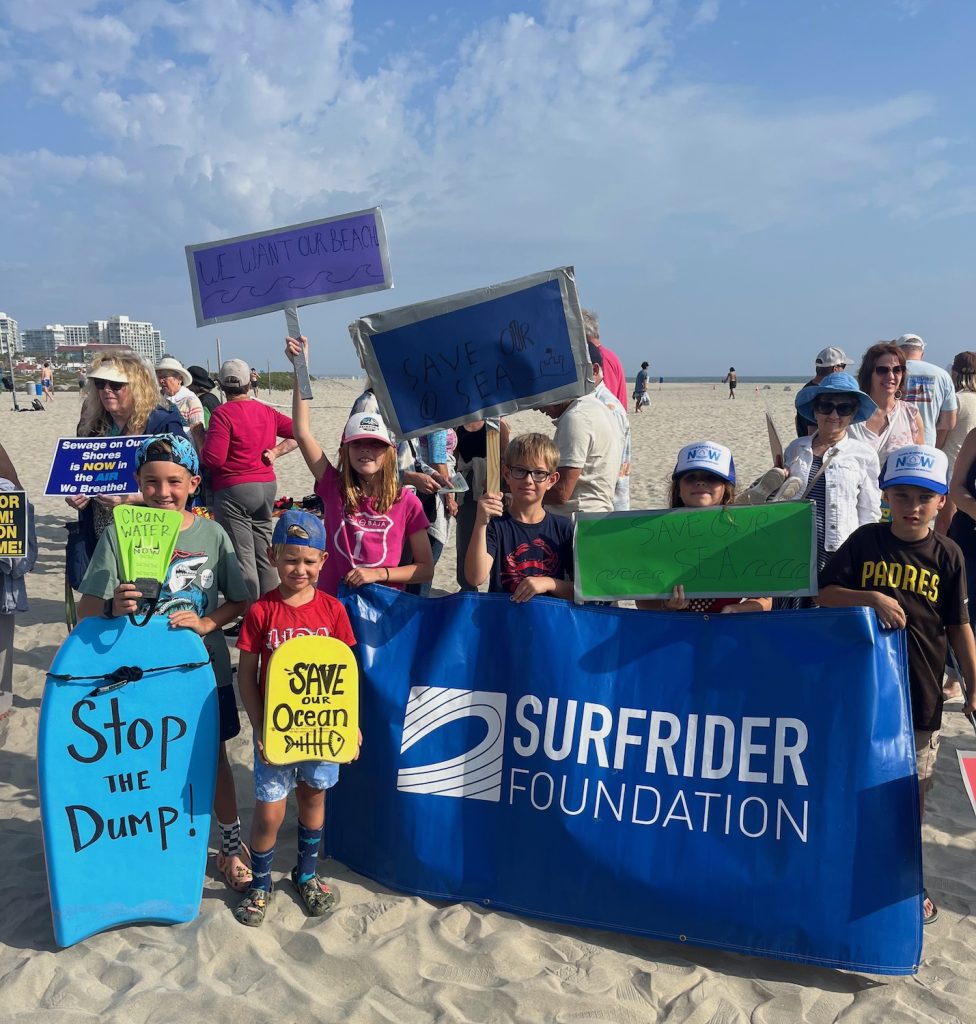 Kids at a San Diego rally demanding clean water and holding up a Surfrider Foundation banner 
