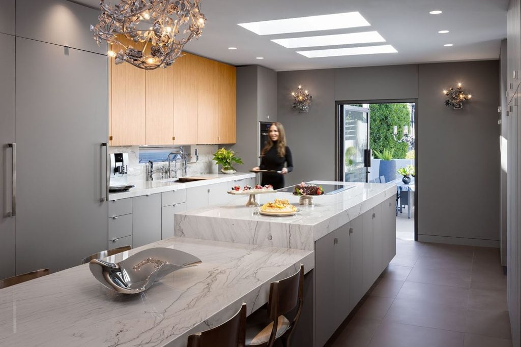 Extraordinary Desserts founder Karen Krasne in her kitchen with a table filled with cakes and other sweets