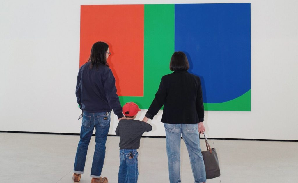 Parents holding hands with their child and looking at a work of art at the Museum of Contemporary Art San Diego