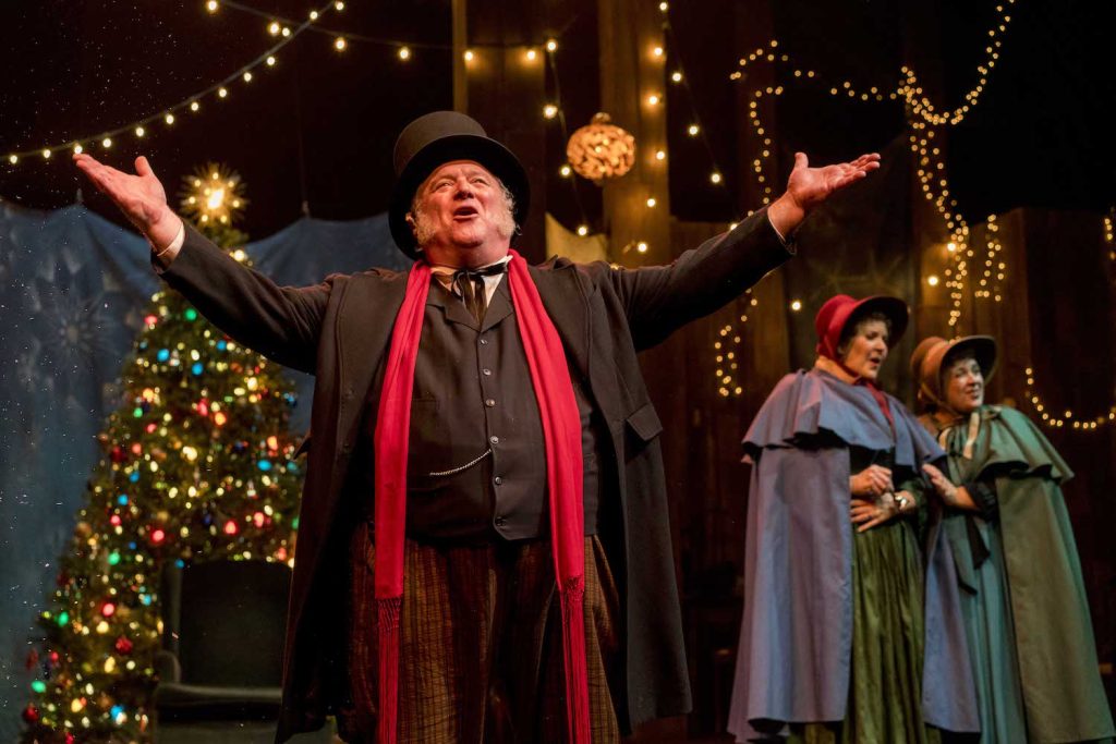 Old man in old clothes singing on stage for A Christmas Carol at Cygnet Theatre, San Diego
