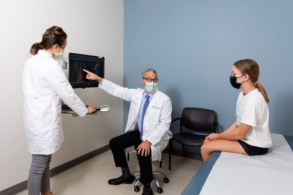 Doctor point to x-ray and assisting child at Rady Children's Hospital