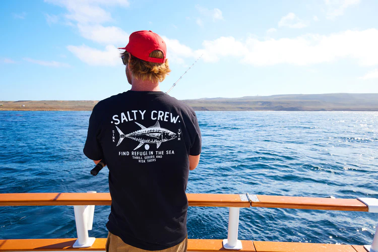 Man fishing while wearing a shirt from San Diego brand, Salty Crew