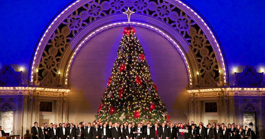Things to do in San Diego December 2023: A choir singing at Balboa Park's December Nights Event in front of the Spreckels Organ Pavilion. Things to do this December 2023