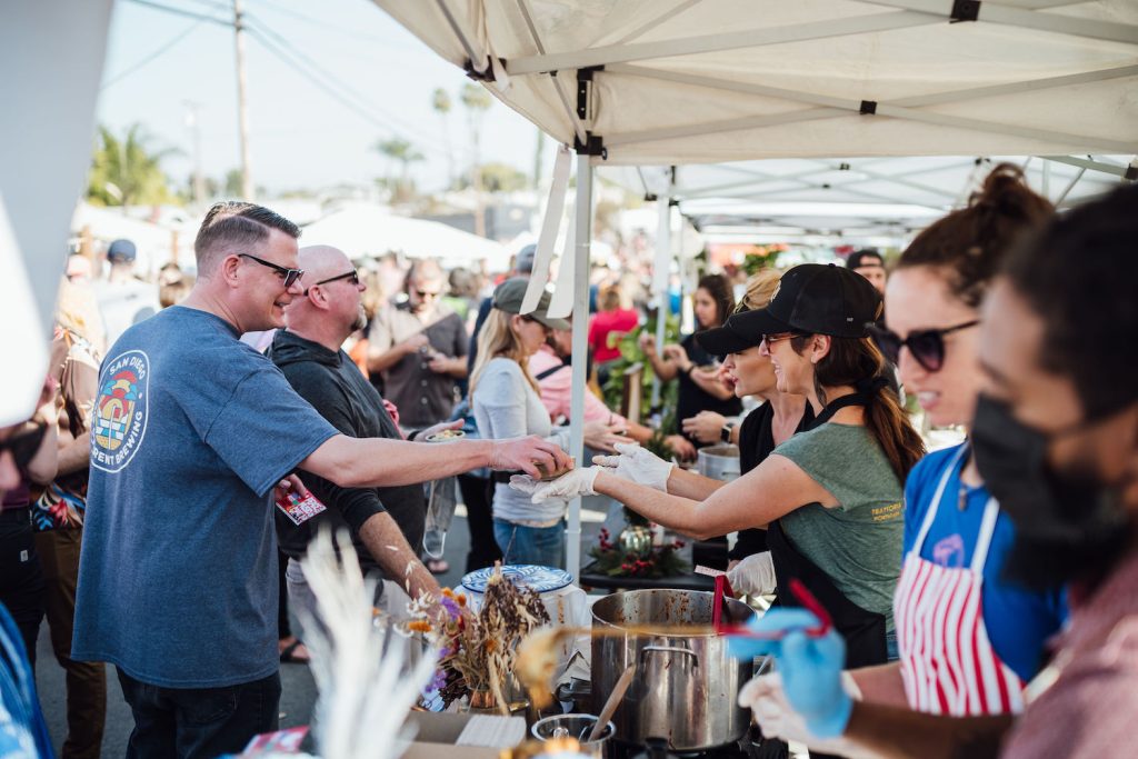 People being served chili during the SoNo Fest & Chili Cook-Off event in North Park