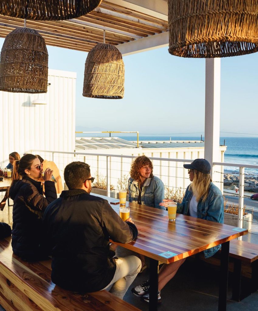 Table of beer drinkers at Wendlandt Tasting Room in Baja California with an oceanfront view