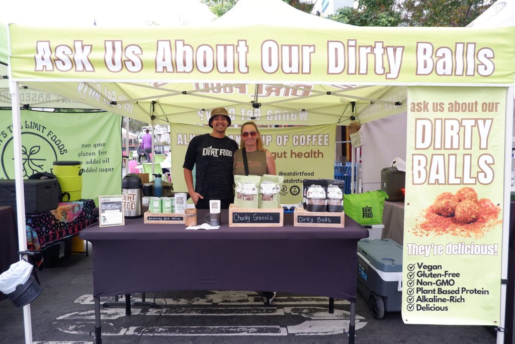Mother and Son founders of Dirt Food  Nikka and Anthony Blunt at a farmers market stand in San Diego