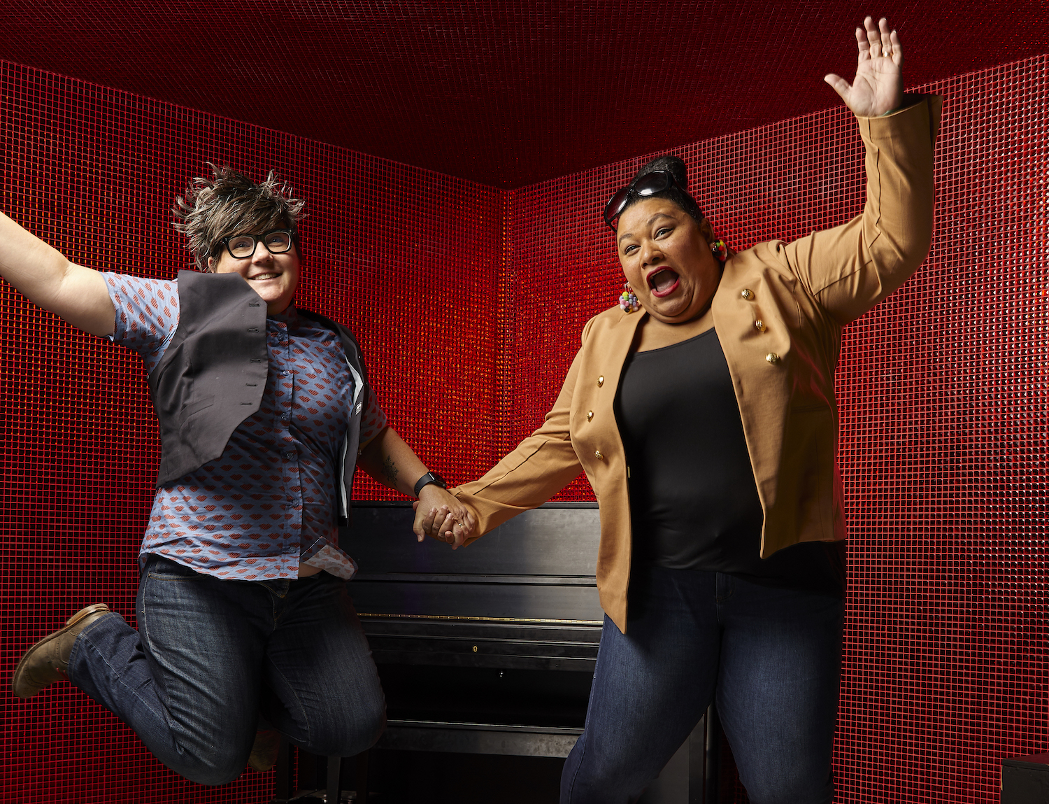 Jenny Case (left), executive director at Diversionary Theatre, and Desireé Clarke Miller, Moxie Theatre’s artistic director, jumping off a stage