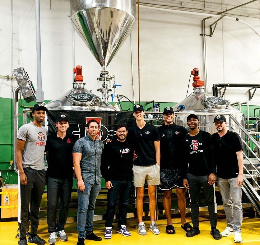 SDSU Basketball players alongside members of Novo Brazil Brewing company