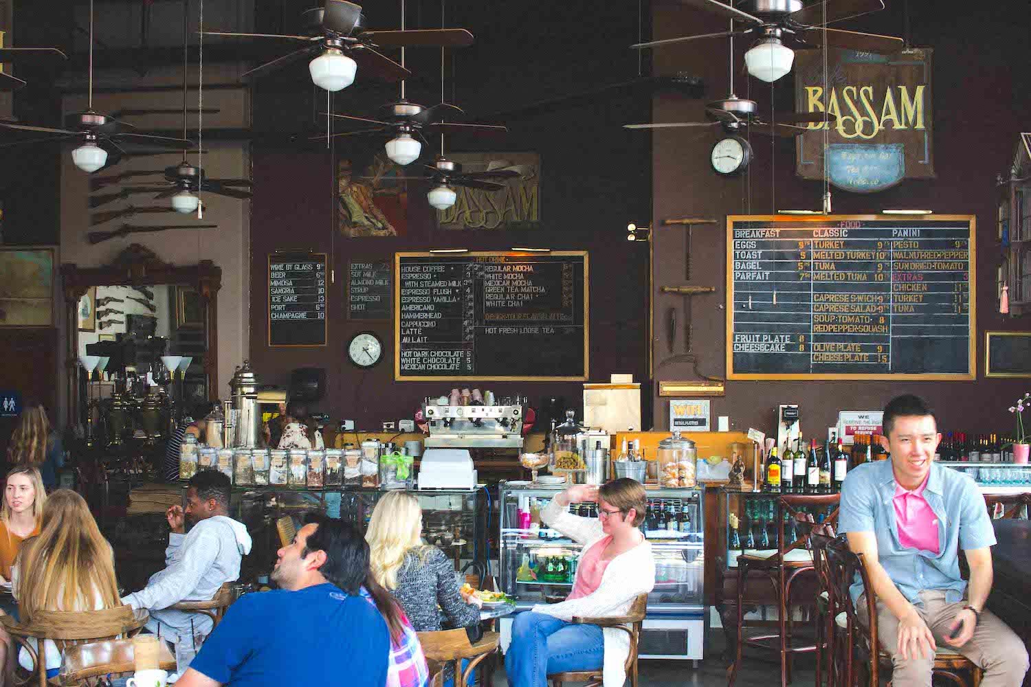 Interior of San Diego coffee shop Cafe Bassam featuring antiques, tea, wine, cigars, and a menu written on a chalkboard located in Bankers Hill