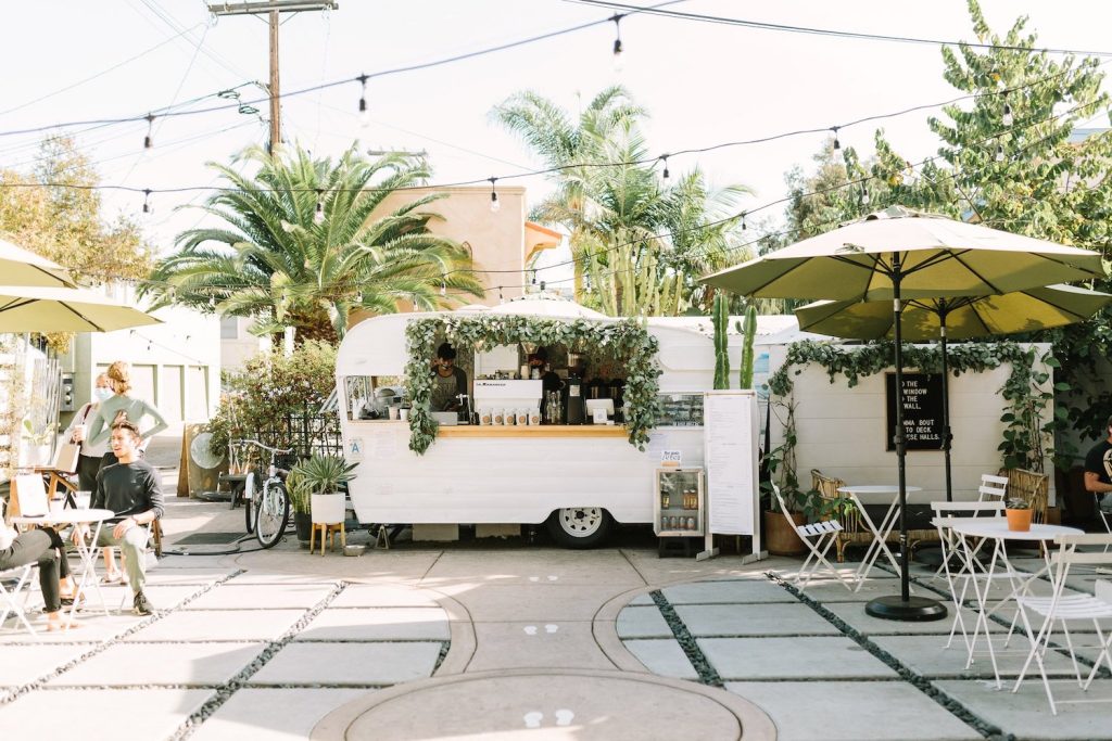 Communal Coffee in South Park featuring a trailer shop for baristas, outdoor patio seating, and a boutique shop next door