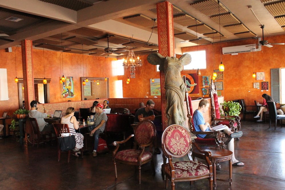 Interior of Lestat's on Park located in University Heights featuring students working, statues, and unique throne chairs