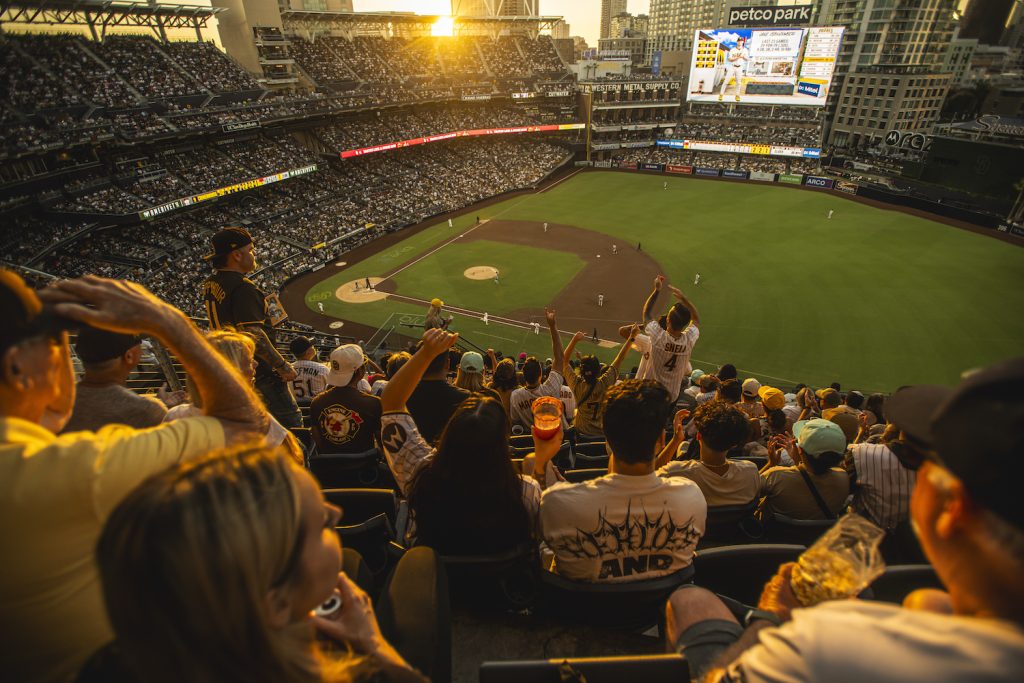 San Diego padres fans cheer at Petco Park during an MLB game at sunset