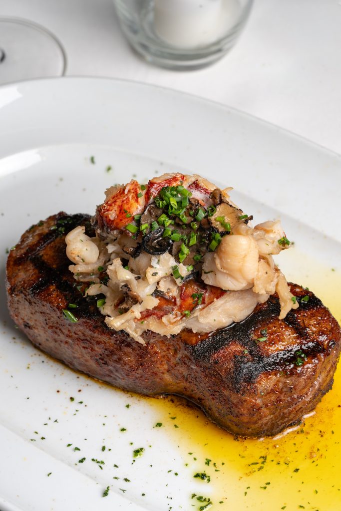A steak from Del Mar, San Diego's Steak 48, on a plate topped with chives