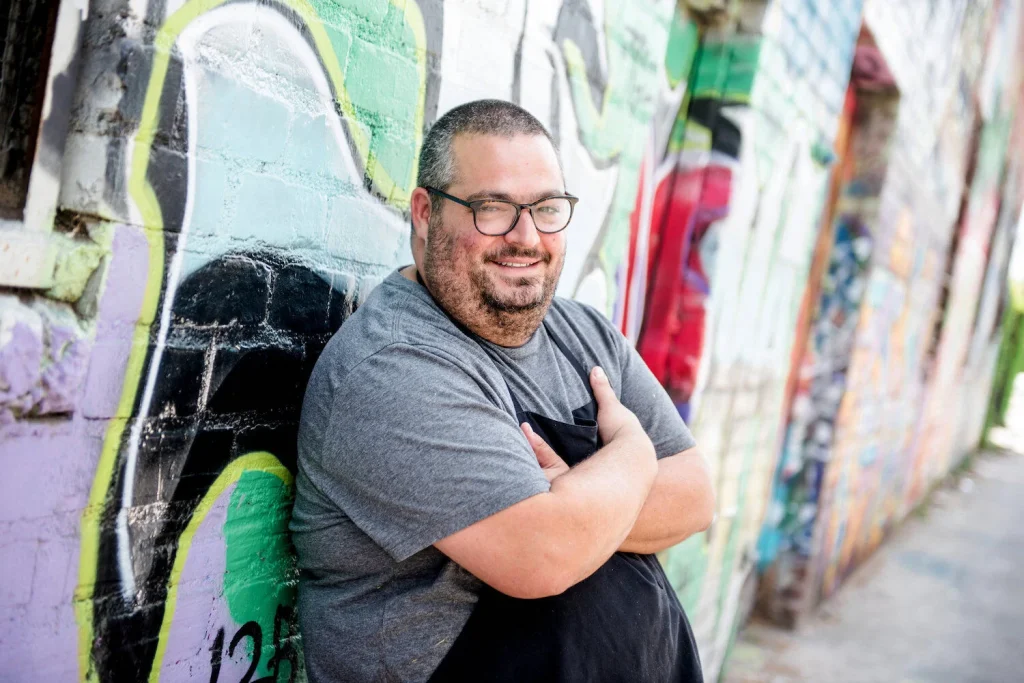 Chef and cheesemaker Eric Greenspan standing against a wall