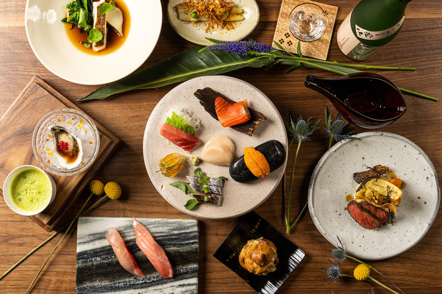 Best New San Diego restaurant opening in 2023 Kinme in Banker's Hill featuring a table full of sushi, appetizers, and beverages
