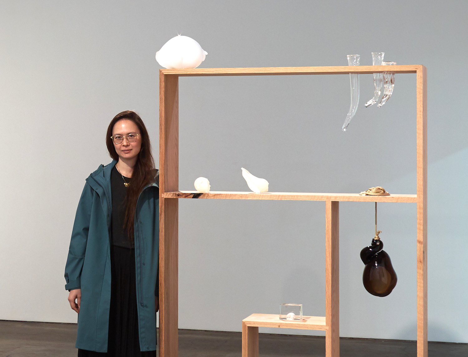 Los Angeles artist Kelly Akashi standing next to one of her installments at an art exhibit