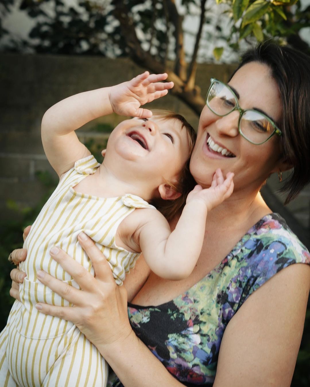 SDM contributor María José Durán smiling and holding one of her kids outside