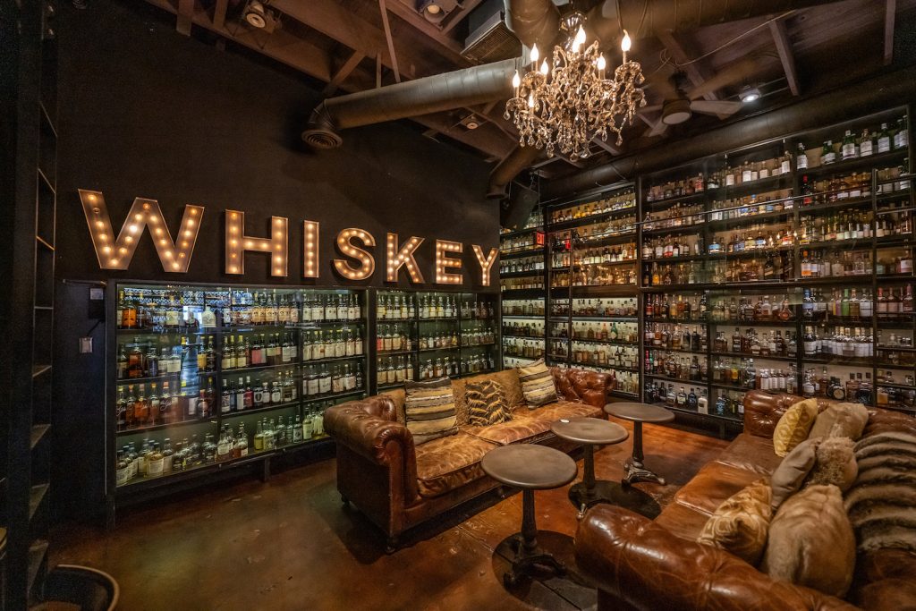 San Diego's best whiskey bar, The Whiskey House, located in the Gaslamp quarter featuring a rare whiskey collection, walls of bottles and glasses at a bar