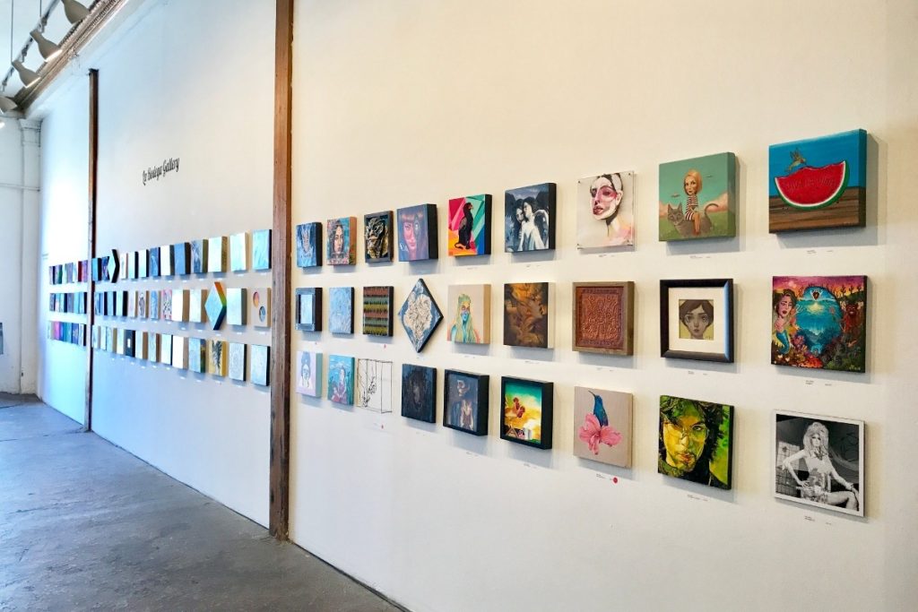La Bodega Art Gallery in Barrio Logan San Diego featuring a wall of paintings by local artists in San Diego and Tijuana