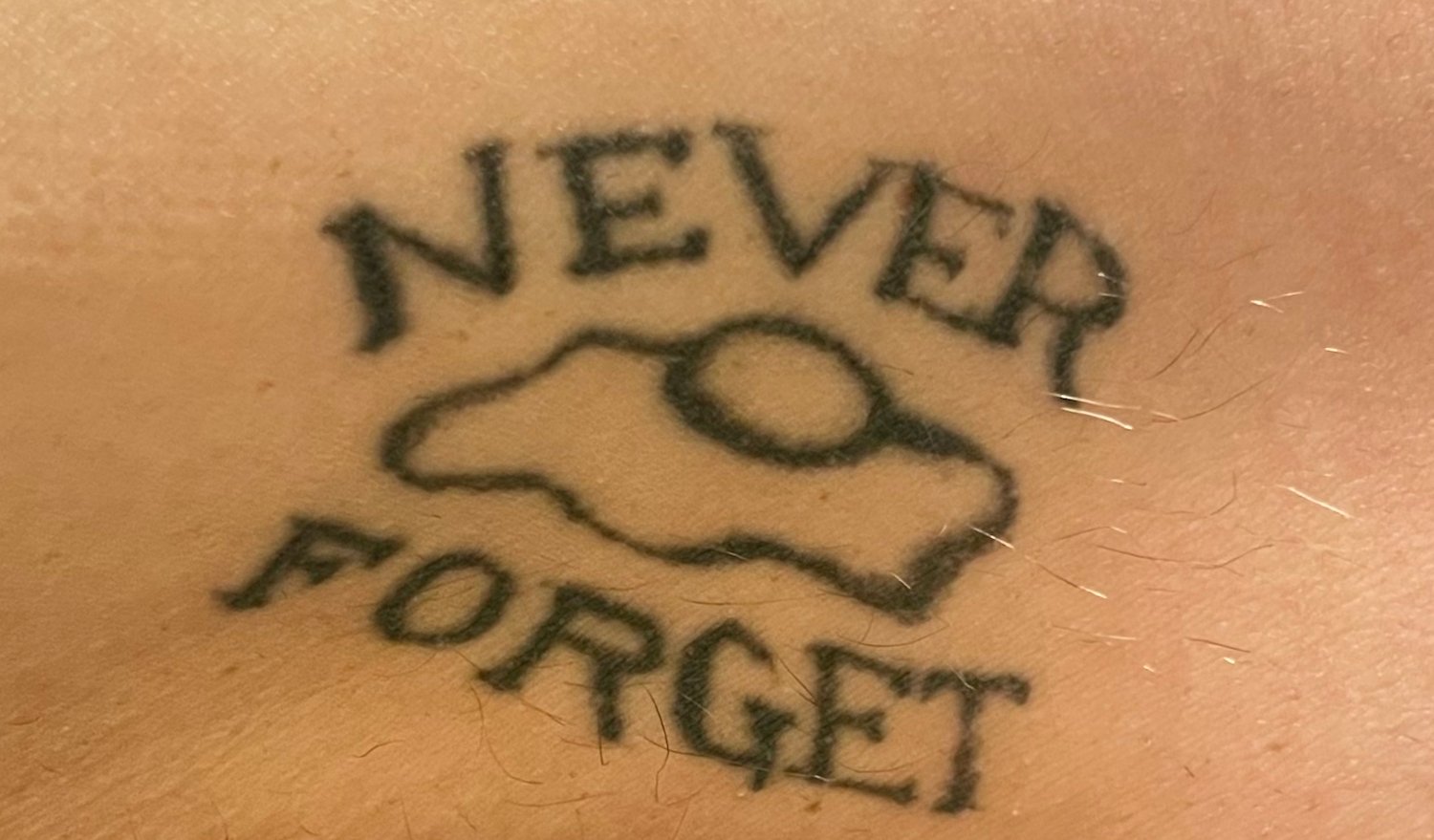 San Diego regrettable tattoo of an egg featuring the text "Never Forget"