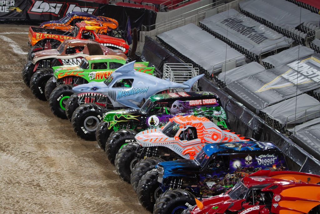 A row of monster trucks lined up at Snapdragon Stadiums first Monster Jam in January 2024