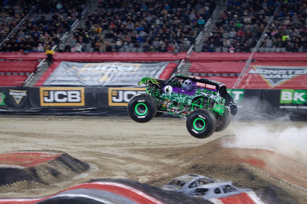 Grave Digger monster truck performing a jump at the 2024 Monster Jam event at Snapdragon Stadium
