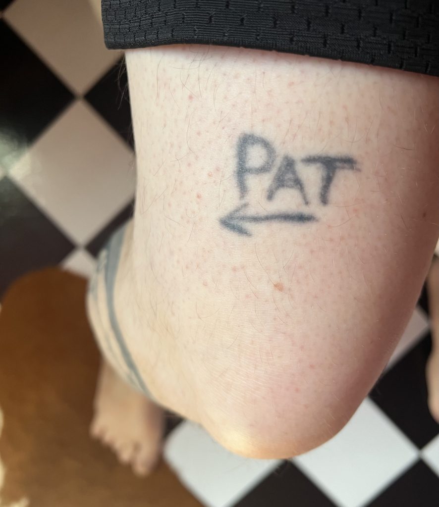 San Diego Magazine's user submitted regrettable tattoos featuring a leg tattoo with the text "Pat" with an arrow
