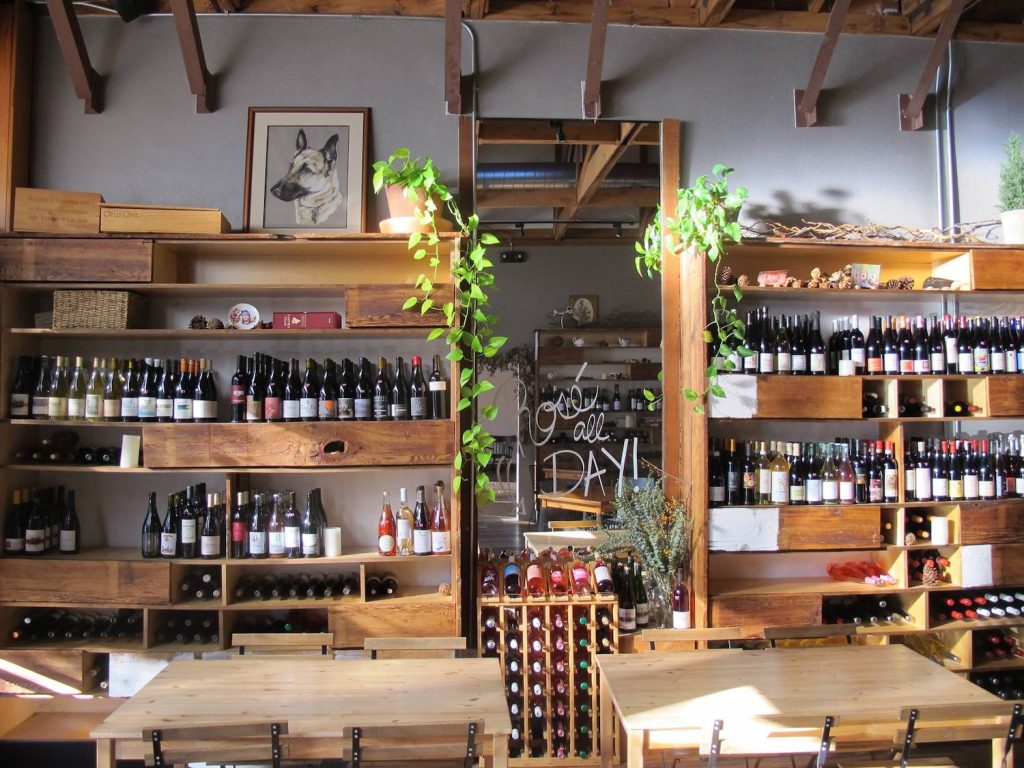 San Diego's best wine bar, The Rose Wine Bar, located in South Park and featuring a collection of wine bottles along with wood tables and plants