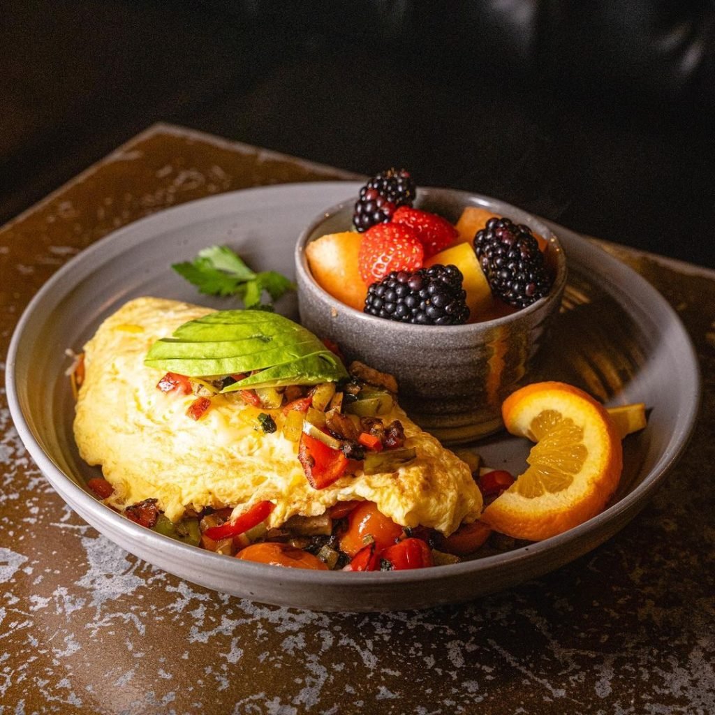 An omelette topped with avocado and a side of berries from A Little Moore Cafe in Leucadia near Encinitas, San Diego