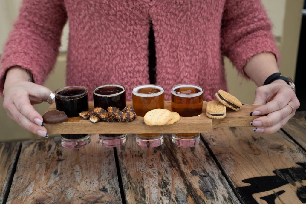 Person holding a tray of Girl Scout Cookies along with San Diego beers as part of a cookie-beer tasting at local breweries