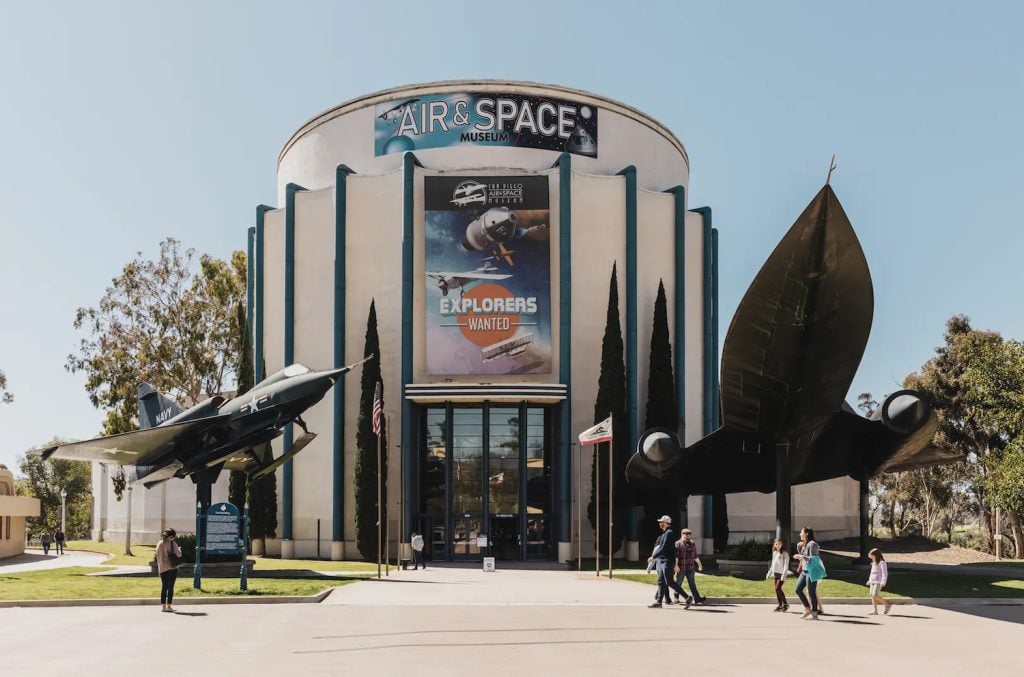 Exterior of the San Diego Air and Space Museum featuring a blackbird and a fighter jet in front of the building in Balboa Park, San Diego