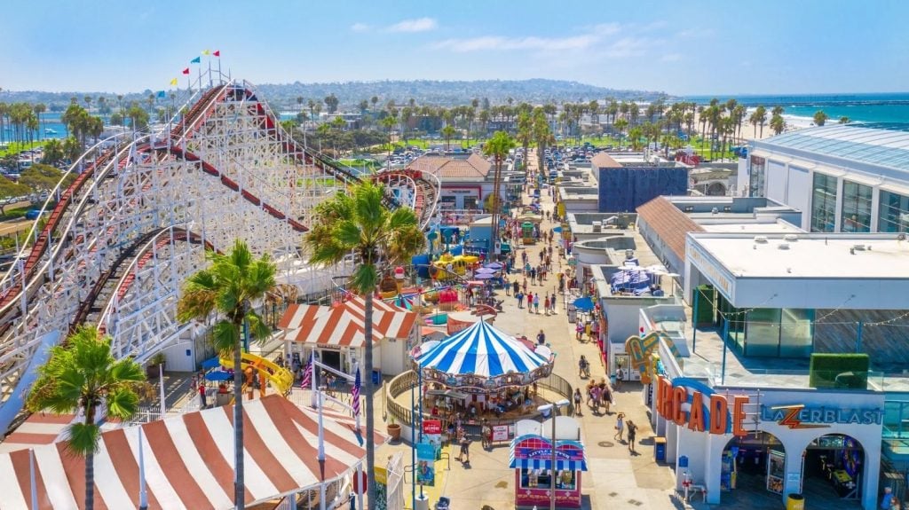 Popular San Diego date spot, Belmont Park in Mission Beach featuring an aerial view of the boardwalk, amusement rides, and attarctions