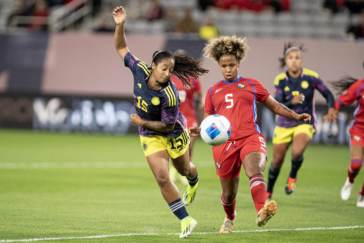 Group stage Women's Concacaf Gold Cup soccer match between Colombia and Panama with two players fighting over the ball