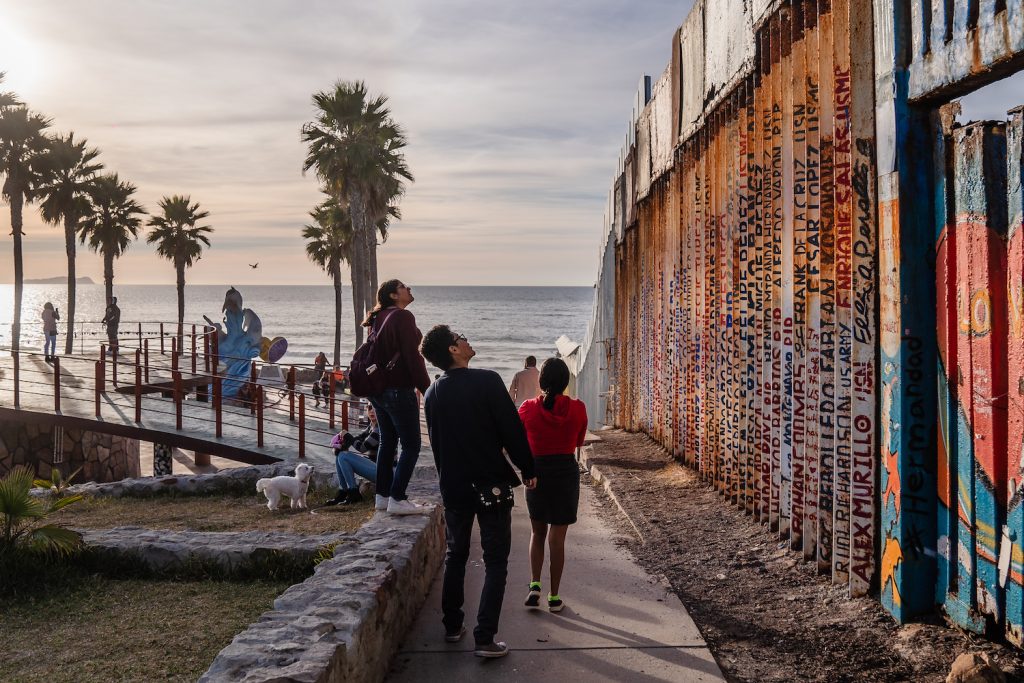 Tijuana residents looking at the murals on the Tijuana-San Diego US-Mexico border wall from Playas de Tijuana 