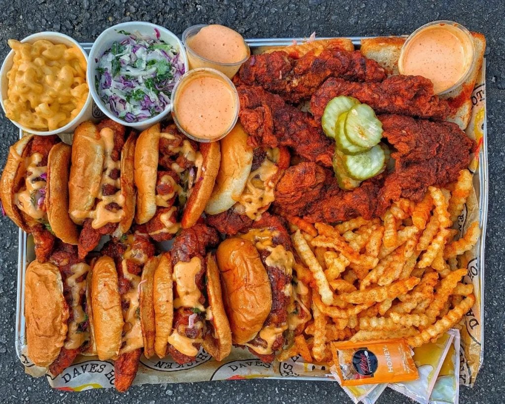 Tray full of chicken sandwiches, chicken wings, fries, and sides from Dave's Hot Chicken which is opening a new restaurant in Mission Valley, San Diego