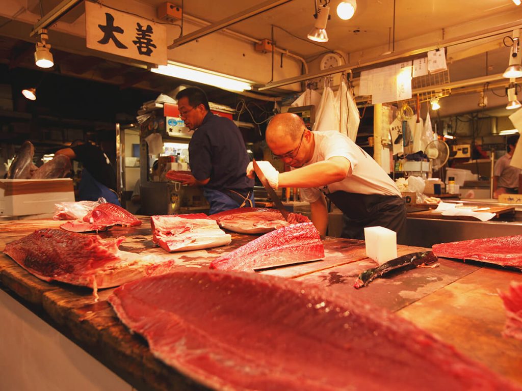A man fileting a large fish at the Tsukiji Fish Market in Tokyo, Japan