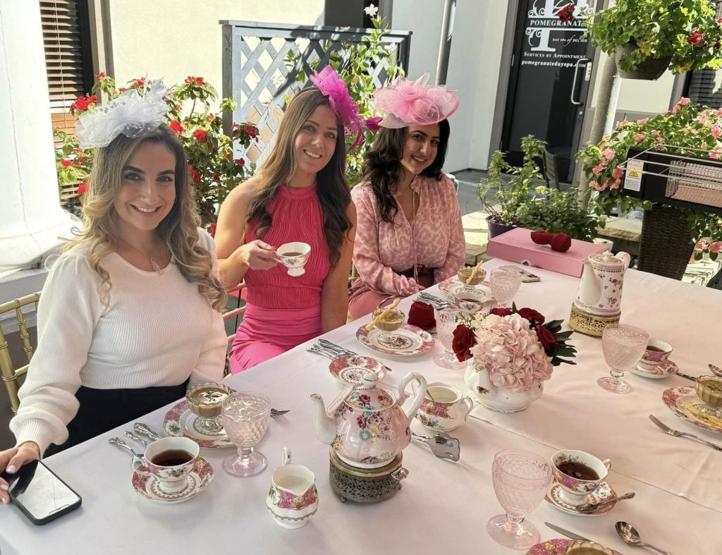 Three women wearing afternoon tea attire and sitting at a table outside of Marlene's Tea & Cakes teahouse in Black Mountain Ranch, San Diego 