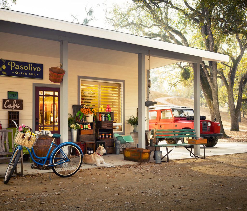 Exterior of Pasolivo olive oil shop with a dog, bike, and vintage car in Paso Robles, California