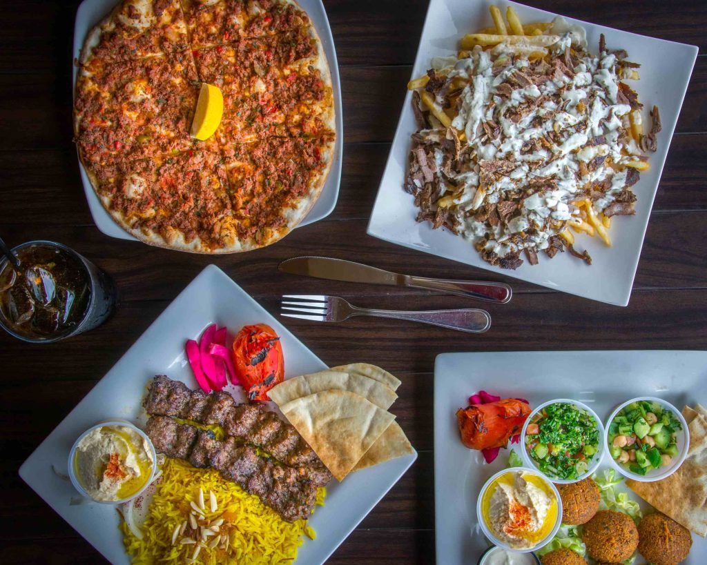 Middle Eastern restaurant Sahara: Taste of the Middle East in El Cajon, San Diego featuring a table full of meat dishes, flatbread, and falafel